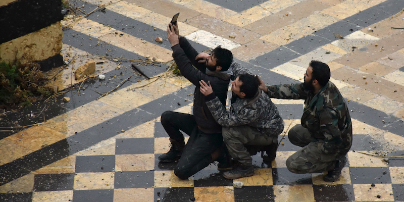 Tre uomini delle forze di Assad si fanno un selfie fuori da una moschea di Aleppo (GEORGE OURFALIAN/AFP/Getty Images)