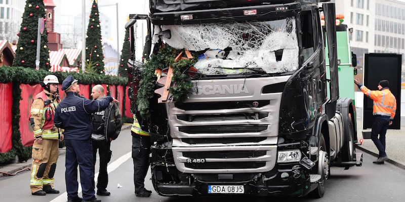 Un poliziotto e alcuni vigili del fuoco vicino al camion usato per l'attacco a Berlino, il 20 dicembre 2016 (TOBIAS SCHWARZ/AFP/Getty Images)