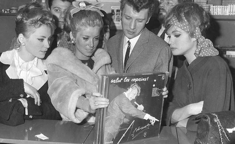 Johnny Hallyday e Catherine Deneuve guardano dei dischi di Hallyday in un negozio di Parigi nel 1962 (Keystone/Hulton Archive/Getty Images)
