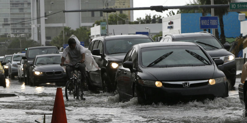 Il traffico in una strada inondata di Miami Beach, in Florida, il 23 settembre 2014 (AP Photo/Lynne Sladky)