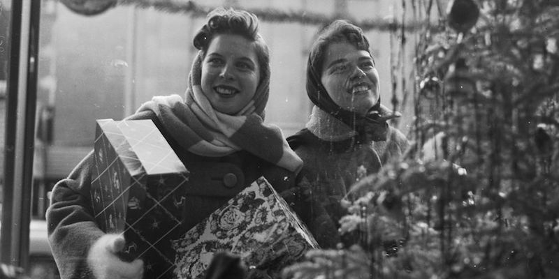 Due ragazze guardano le vetrine di Natale con alcune scatole in mano probabilmente nel 1955, Washington D.C.
(Orlando /Three Lions/Getty Images)