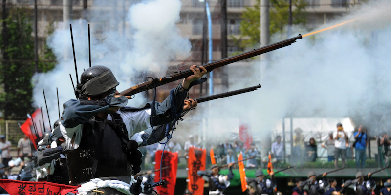 Alcune persone vestite da samurai mostrano antichi fucili a miccia durante un evento a Tokyo
(RIE ISHII/AFP/Getty Images)