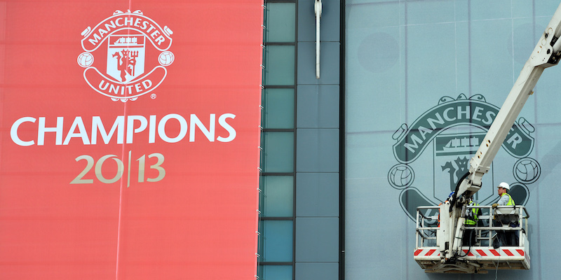 Due operai lavorano alla facciata esterna dell'Old Trafford di Manchester (PAUL ELLIS/AFP/Getty Images)