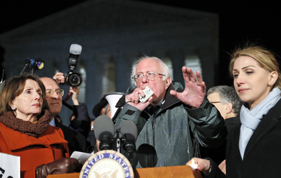 Il senatore Democratico Bernie Sanders con Nancy Pelosi, leader della minoranza alla Camera degli Stati Uniti, e altri membri del Congresso a una manifestazione contro Trump davanti alla Corte Suprema, Washington D.C. - 30 gennaio 2017
(AP Photo/Alex Brandon)
