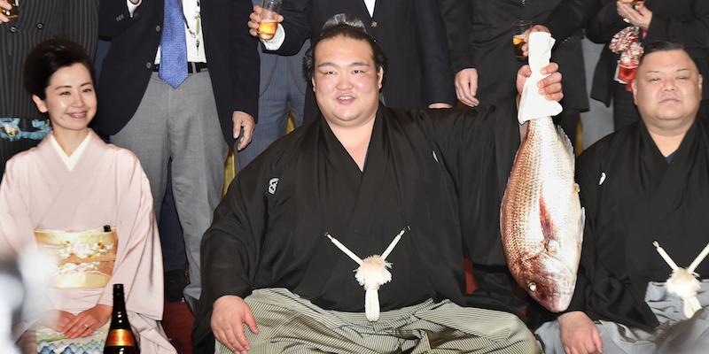 Kisenosato Yutaka regge un'orata di dieci chili durante la celebrazione per il titolo di yokozuna (AP)