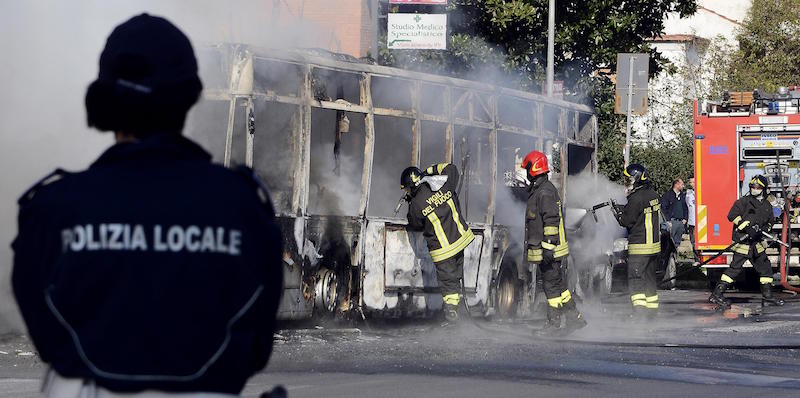 Un gruppo di pompieri tenta di spegnere l'incendio avvenuto su un autobus a Ciampino, 21 marzo 2017 (ANSA/CLAUDIO ONORATI)