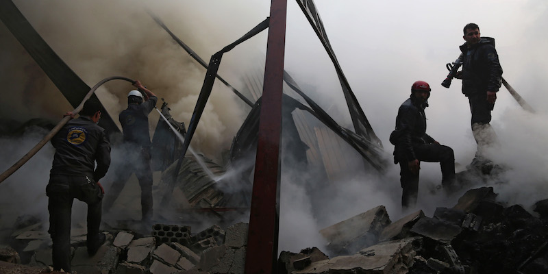 Uomini dei Caschi bianchi cercano di spegnere un incendio dopo alcuni attacchi aerei su Hamouria, nella zona di Ghouta orientale (AMER ALMOHIBANY/AFP/Getty Images)