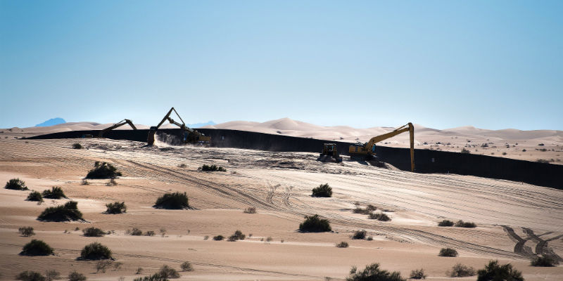 Dei lavori nei pressi della recinzione al confine tra Stati Uniti e Messico, alle Imperial Sand Dunes di Dunes, in California (Jim Watson/AFP/Getty Images)