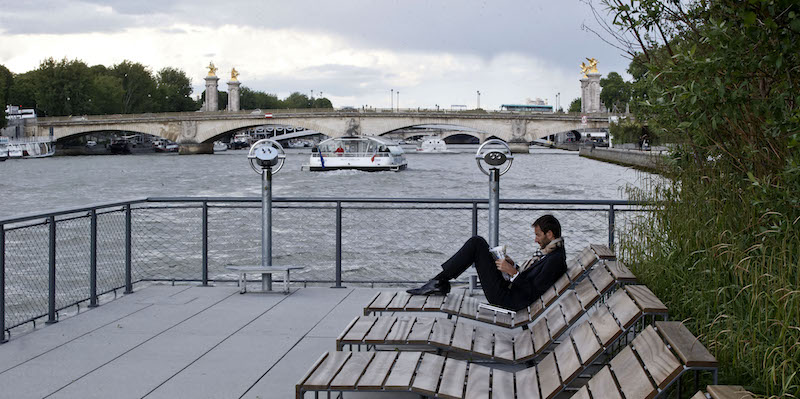 Un uomo legge il giornale sulla riva della Senna, a Parigi (AP Photo/Michel Euler)