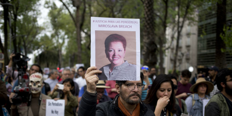 Un uomo regge un cartello con una foto di Miroslava Breach, una giornalista messicana uccisa il 23 marzo, durante una marcia a Messico City, il 25 marzo 2017 (AP Photo/Eduardo Verdugo)