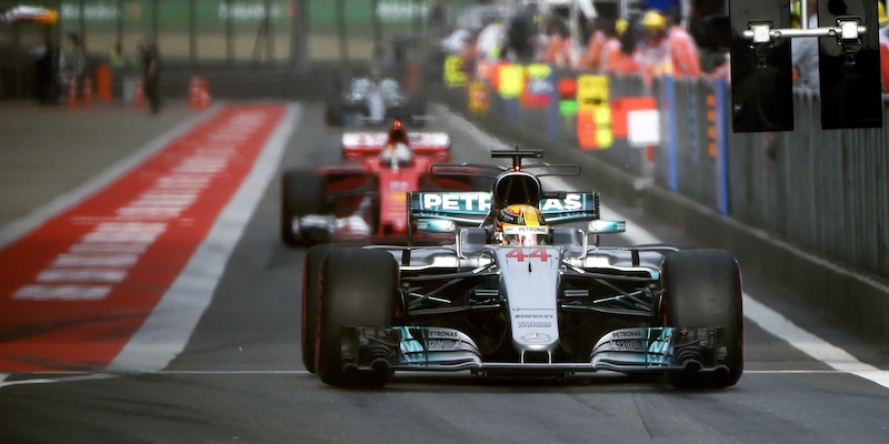 Lewis Hamilton all'uscita dai box seguito da una Ferrari (WANG ZHAO/AFP/Getty Images)