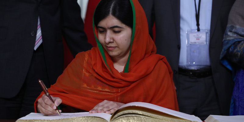 Malala Yousafzai firma il libro degli ospiti al Parlamento di Ottawa, in Canada
(LARS HAGBERG/AFP/Getty Images)