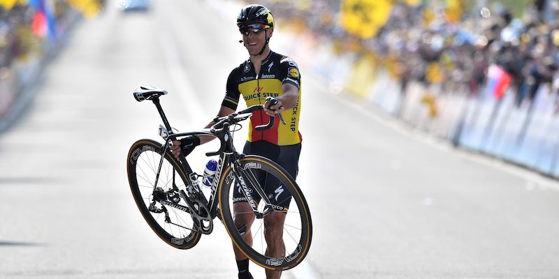 Philippe Gilbert mentre taglia il traguardo a piedi, sollevando la bici con le mani (ERIC LALMAND/AFP/Getty Images)