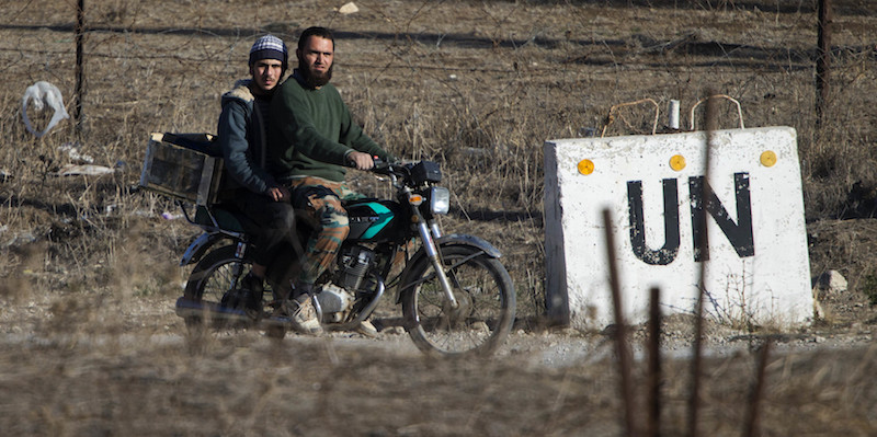 Due uomini percorrono in motorino una strada al confine fra Siria e Israele nelle Alture del Golan (AP Photo/Ariel Schalit)