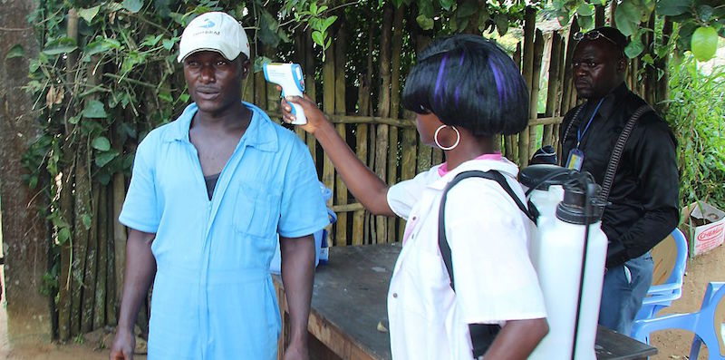 A un uomo viene provata la febbre dopo essere arrivato all'aeroporto di Boende, in Repubblica Democratica del Congo, come parte della profilassi per impedire la diffusione di ebola, 8 ottobre 2014 (KATHY KATAYI/AFP/Getty Images)