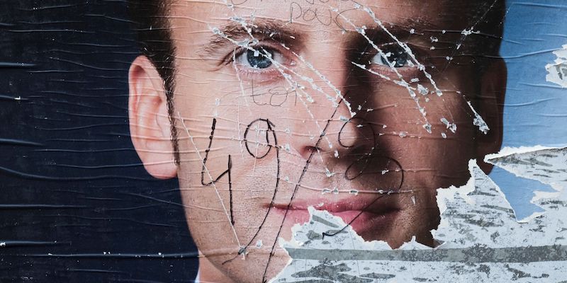 Un manifesto elettorale di Emmanuel Macron vandalizzato a Parigi, il 5 maggio 2017 (JOEL SAGET/AFP/Getty Images)