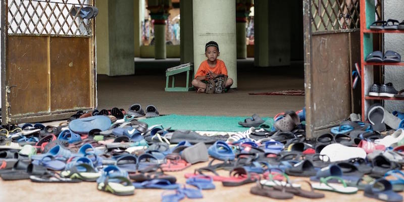 Un bambino siede vicino all'entrata di una moschea a Manila, 27 maggio 2017 (EPA/MARK R. CRISTINO)