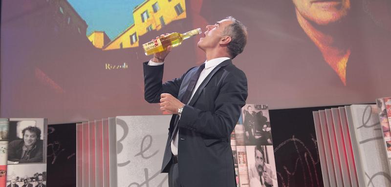 Edoardo Albinati, vincitore del Premio Strega 2016, beve del liquore Strega sul palco. (ANSA/GIORGIO ONORATI)