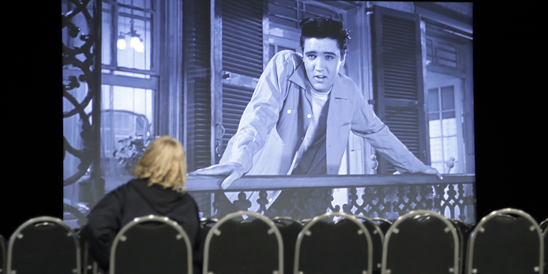 Una donna guarda una scena del film "La via del male" (1958) nel nuovo museo dedicato a Elvis Presley a Memphis, in Tennessee, il 2 marzo 2017 (AP Photo/Mark Humphrey)