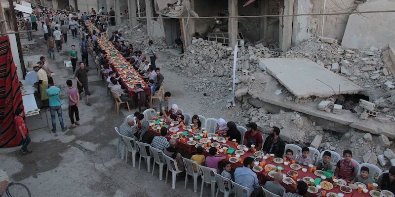 Cittadini di Douma, una città sotto il controllo dei ribelli siriani vicina a Damasco, cenano insieme, il 18 giugno 2017 (HAMZA AL-AJWEH/AFP/Getty Images)