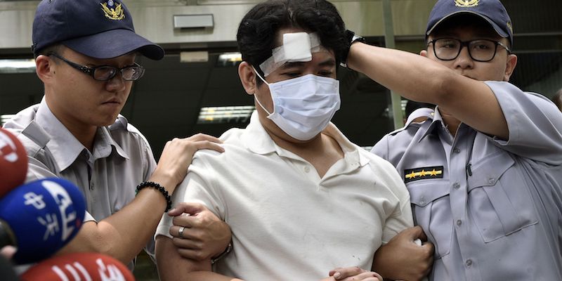 L'uomo che ha aggredito un militare fuori dal palazzo presidenziale di Taipei, il 18 agosto 2017, mentre viene scortato in una stazione di polizia (SAM YEH/AFP/Getty Images)