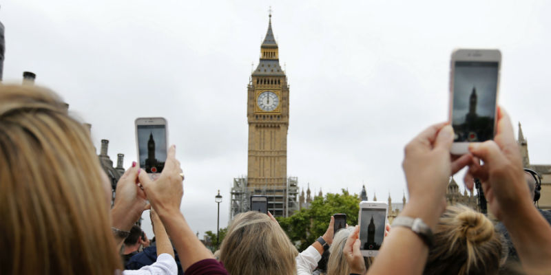 Diverse persone registrano i dodici rintocchi del Big Ben, oggi a mezzogiorno: salvo eventi speciali, l'orologio non suonerà più per almeno 4 anni (Frank Augstein/AP Images)