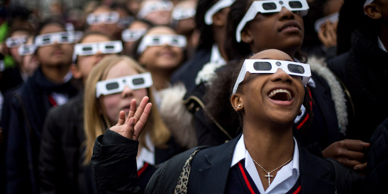 Un gruppo di studentesse al Royal Observatory di Greenwich, nel Regno Unito, per l'eclissi solare totale di due anni fa, il 20 marzo 2015: indossano gli occhiali protettivi fatti apposta (Rob Stothard/Getty Images)