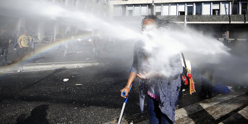 La foto di una rifugiata con una stampella colpita da un idrante a Roma