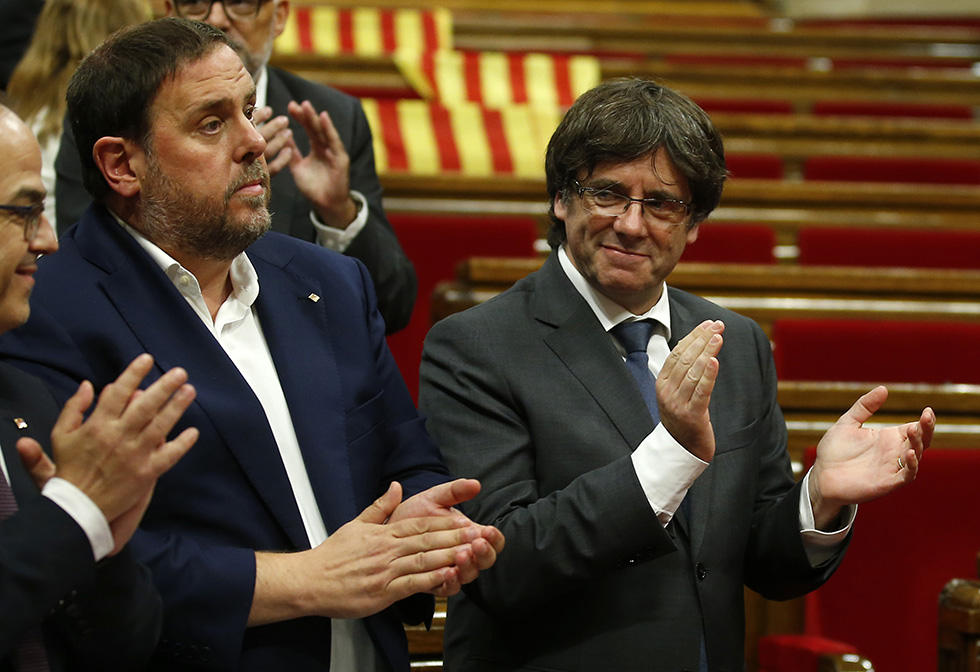 Il presidente della Catalogna Carles Puigdemont, a destra, applaude con il vicepresidente Oriol Junqueras, a sinistra, dopo il voto favorevole del parlamento su una legge che consente di convocare il referendum della regione sull'indipendenza, Barcellona, 6 settembre 2017
(AP Photo/Manu Fernandez)