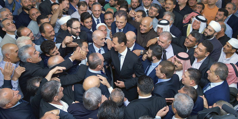 Il presidente siriano Bashar al Assad circondato dalla folla a Qarat, Siria (SANA via AP)
