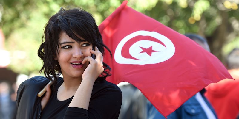 Una donna tunisina con una bandiera del suo paese a Tunisi, il 14 gennaio 2016 (FETHI BELAID/AFP/Getty Images)