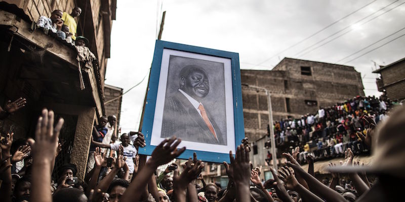 Un ritratto di Raila Odinga tenuto in mano da alcuni suoi sostenitori durante una manifestazione a Nairobi, il 13 agosto (MARCO LONGARI/AFP/Getty Images)