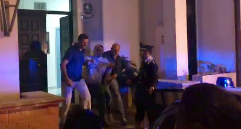 Un fermo immagine tratto da un video dell'ANSA mostra il 17enne portato fuori dalla stazione dei carabinieri di Specchia, 14 settembre 2017.
(ANSA)