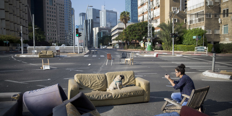 Un cane siede su un divano piazzato sulle strade deserte durante lo Yom Kippur a Ramat Gan, periferia di Tel Aviv, 29 settembre 2017 (AP Photo/Oded Balilty)
