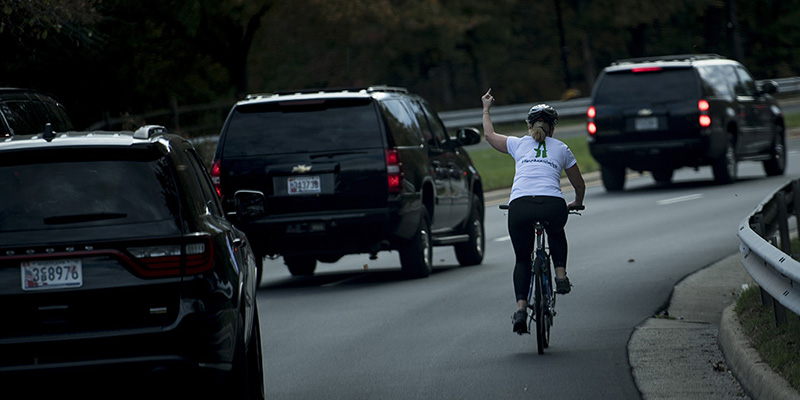 Una donna in bicicletta fa il dito medio al corteo presidenziale di Trump, Sterling, Virginia, 28 ottobre 2017
(Brendan Smialowski -
AFP/Getty Images)