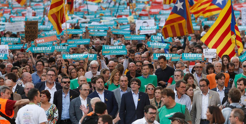 Alcuni membri del governo catalano, tra cui il presidente Carles Puigdemont, a una manifestazione a Barcellona (PAU BARRENA/AFP/Getty Images)