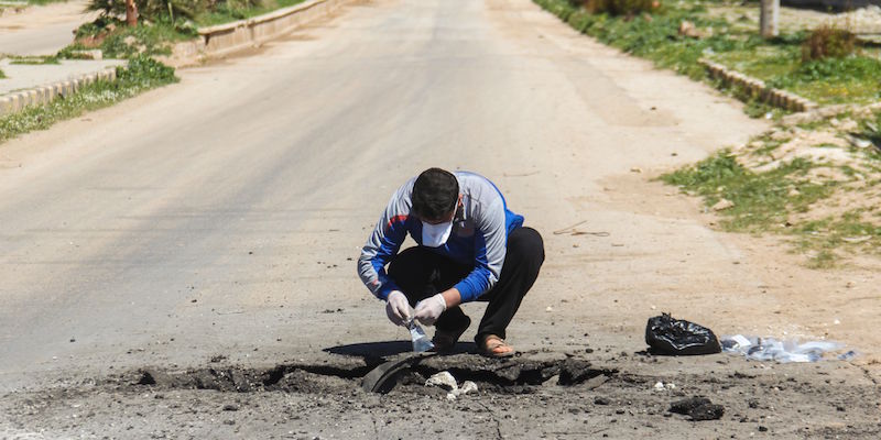 Un uomo raccoglie le prove dell'attacco col sarin a Khan Shaykhun (OMAR HAJ KADOUR/AFP/Getty Images)