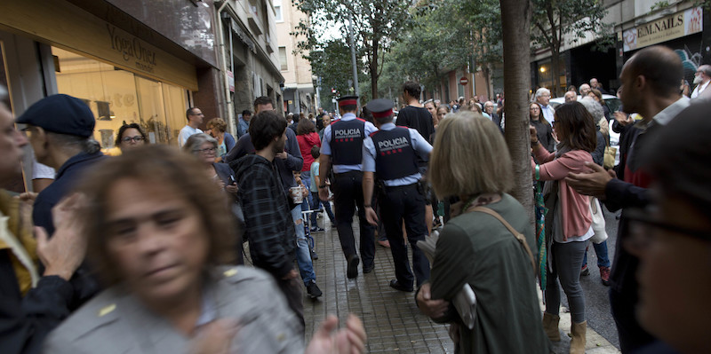 Due agenti dei Mossos d'Esquadra a Barcellona, fuori da un seggio elettorale, 1 ottobre 2017 (AP Photo/Enric Marti)