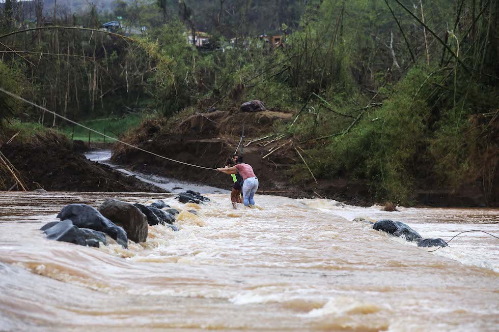 Tre persone usano una corda per attraversare il fiume di San Lorenzo de Morovis, dopo che un ponte è stato distrutto, San Lorenzo, 6 ottobre 2017
(Mario Tama/Getty Images)