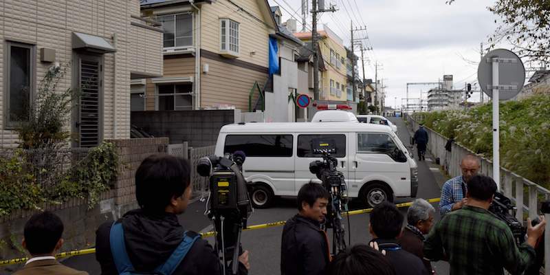 Un gruppo di giornalisti vicino alla casa di Takahiro Shiraishi il cui ingresso è stato coperto dalla polizia con un telone blu, il 31 ottobre 2017, a Zama, in Giappone (TORU YAMANAKA/AFP/Getty Images)