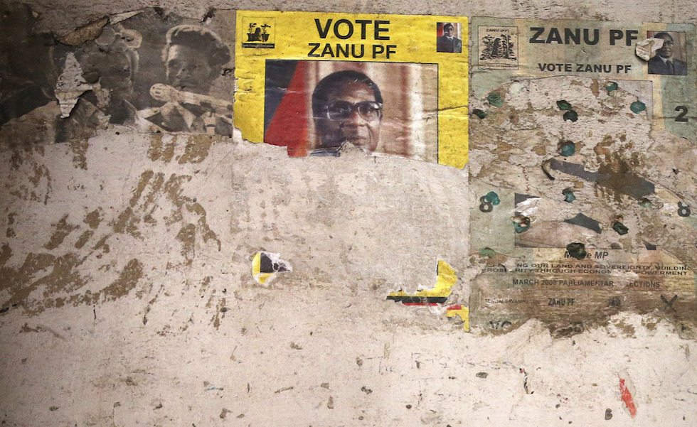 Un poster elettorale del del partito Zanu-PF, il partito del presidente Robert Mugabe, recentemente emarginato dall'esercito. Oggi ad Harare si terrà una manifestazione per chiedere la destituzione definitiva di Mugabe, dopo l'iniziativa dell'esercito. (AP Photo)