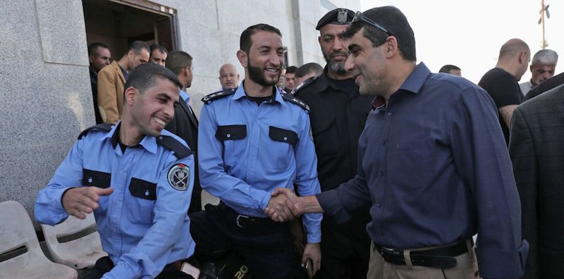 Un funzionario di Fatah stringe la mano ad alcuni membri dell'apparato di sicurezza di Hamas durante il trasferimento del controllo della frontiera di Rafah, 1 novembre 2017 (SAID KHATIB/AFP/Getty Images)