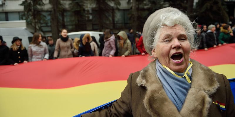 Una donna moldava protesta con altre persone davanti al parlamento di Chisinau per denunciare irregolarità nelle elezioni presidenziali (DANIEL MIHAILESCU/AFP/Getty Images)