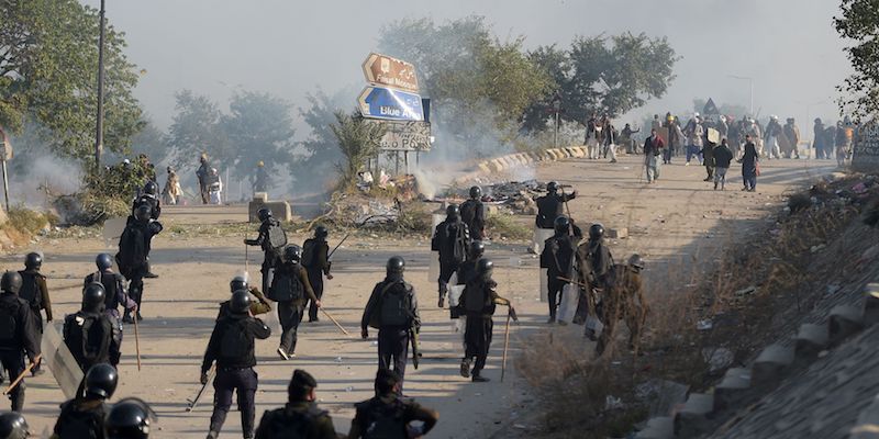 Poliziotti in tenuta d'assalto durante gli scontri con i membri del partito Tehreek-i-Labaik Ya Rasool Allah sul raccordo autostradale da questi occupato, intorno a Islamabad, il 25 novembre 2017 (AAMIR QURESHI/AFP/Getty Images)
