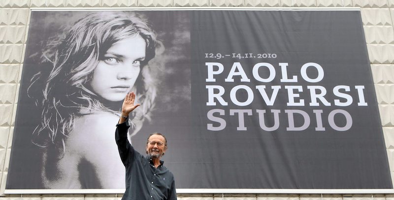 Paolo Roversi davanti a un manifesto su una sua mostra alla galleria d'arte di Kunsthalle a Rostock, in Germania, nel settembre 2010 (EPA/BERND?WUESTNECK)