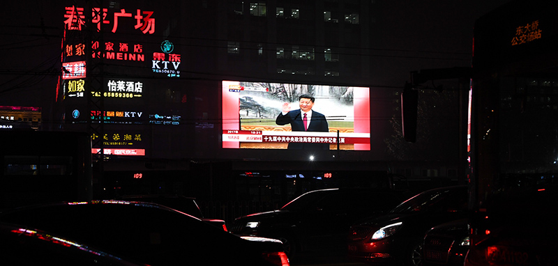 Il presidente cinese Xi Jinping su un grande schermo davanti al traffico a Pechino, il 25 ottobre 2017 (GREG BAKER/AFP/Getty Images)