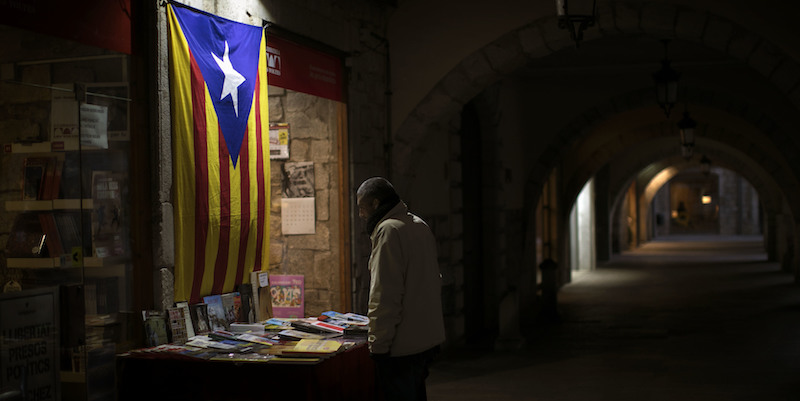 Un uomo di fronte a una bandiera indipendentista a Girona (AP Photo/Emilio Morenatti)