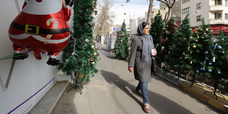 Una donna iraniana cammina per una strada di Teheran, passando vicino ad alcune decorazioni natalizie, il 24 dicembre 2017 (ATTA KENARE/AFP/Getty Images)