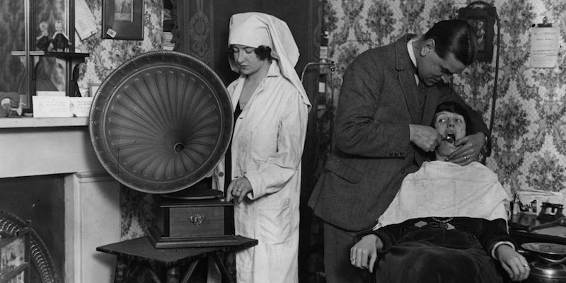 L'assistente di un dentista fa suonare un grammofono ad alto volume per distrarre il paziente dal dolore dell'operazione, nel 1922
(Topical Press Agency/Getty Images)