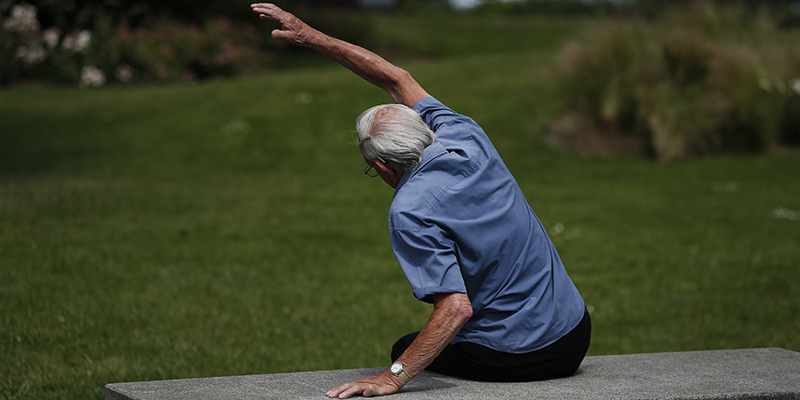 Un uomo anziano fa ginnastica in un parco di Londra, giugno 2014.(AP Photo/Lefteris Pitarakis)